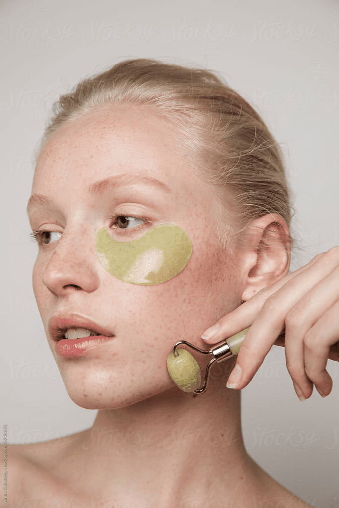 Model With Green Jade Roller And Under eye Patch by Stocksy Contributor Anna Tabakova